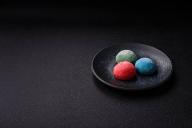 Japon mochi, dondurma ya da meyveli pirinç unundan yapılmış Asya tatlısı. Farklı renklerde mochi ve yiyecek arka planı olarak meyve dolgu