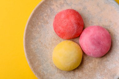 Japon mochi, dondurma ya da meyveli pirinç unundan yapılmış Asya tatlısı. Farklı renklerde mochi ve yiyecek arka planı olarak meyve dolgu