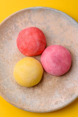 Japon mochi, dondurma ya da meyveli pirinç unundan yapılmış Asya tatlısı. Farklı renklerde mochi ve yiyecek arka planı olarak meyve dolgu