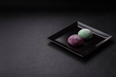 Japon mochi, dondurma ya da meyveli pirinç unundan yapılmış Asya tatlısı. Farklı renklerde mochi ve yiyecek arka planı olarak meyve dolgu