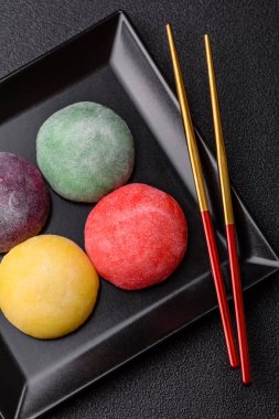 Japon mochi, dondurma ya da meyveli pirinç unundan yapılmış Asya tatlısı. Farklı renklerde mochi ve yiyecek arka planı olarak meyve dolgu