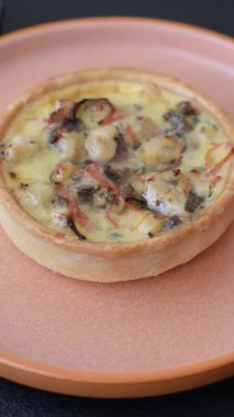 Turta ya da kiş, ekşi bir tart tavuk ve mantarla, baharatlar ve otlar koyu beton arka planda. Tavuklu yuvarlak kiş.