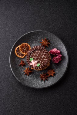 Tatlı tart, çikolatalı turta ve tabakta meyveli krema. Festival masası için çikolatalı tart tatlısı.