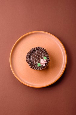 Tatlı tart, çikolatalı turta ve tabakta meyveli krema. Festival masası için çikolatalı tart tatlısı.