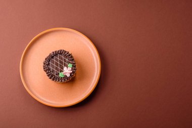 Tatlı tart, çikolatalı turta ve tabakta meyveli krema. Festival masası için çikolatalı tart tatlısı.