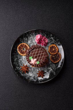 Tatlı tart, çikolatalı turta ve tabakta meyveli krema. Festival masası için çikolatalı tart tatlısı.