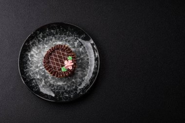 Tatlı tart, çikolatalı turta ve tabakta meyveli krema. Festival masası için çikolatalı tart tatlısı.