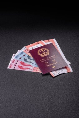Çin, Çin pasaportu, para ve uçak biletleri. Tasarımınız için arka planda biletleri olan Çin pasaportu