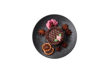 Tatlı tart, çikolatalı turta ve tabakta meyveli krema. Festival masası için çikolatalı tart tatlısı.