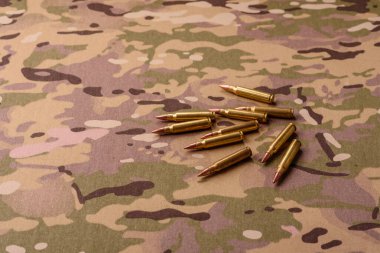 Kamuflaj arka planında makineli tüfek fişekleri, askeri duvar kağıtları. Tasarımınız için bir kamuflaj arkaplanı