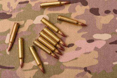 Kamuflaj arka planında makineli tüfek fişekleri, askeri duvar kağıtları. Tasarımınız için bir kamuflaj arkaplanı