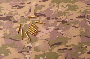 Kamuflaj arka planında makineli tüfek fişekleri, askeri duvar kağıtları. Tasarımınız için bir kamuflaj arkaplanı