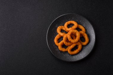 Soğan halkaları ya da soslu ekmek kırıntıları içinde kızarmış mürekkep balığı. Soğan halkaları kızarmış, fast food sizin tasarımınız için bir arka plan.