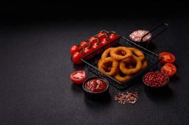 Soğan halkaları ya da soslu ekmek kırıntıları içinde kızarmış mürekkep balığı. Soğan halkaları kızarmış, fast food sizin tasarımınız için bir arka plan.