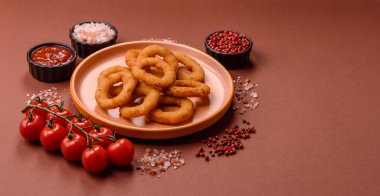 Soğan halkaları ya da soslu ekmek kırıntıları içinde kızarmış mürekkep balığı. Soğan halkaları kızarmış, fast food sizin tasarımınız için bir arka plan.