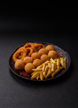 Fast food, peynir topları, soğan ya da kalamar halkaları ve patates kızartması. Tasarımınız için arka plan olarak abur cubur