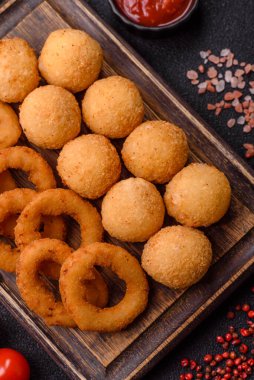 Fast food, peynir topları, soğan ya da kalamar halkaları ve patates kızartması. Tasarımınız için arka plan olarak abur cubur