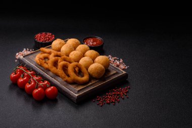 Fast food, peynir topları, soğan ya da kalamar halkaları ve patates kızartması. Tasarımınız için arka plan olarak abur cubur