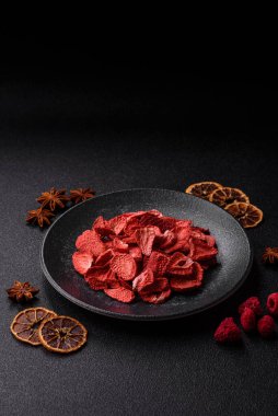 Tatlı tatlılar için bir malzeme olarak kurumuş sublimleşmiş çilek dilimleri. Tasarımınız için yemek arkaplanı olarak kurutulmuş çilek