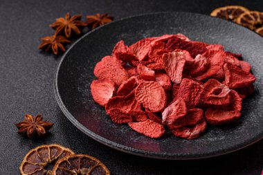 Tatlı tatlılar için bir malzeme olarak kurumuş sublimleşmiş çilek dilimleri. Tasarımınız için yemek arkaplanı olarak kurutulmuş çilek