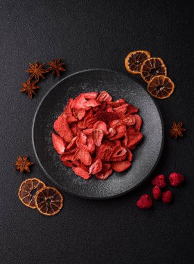 Tatlı tatlılar için bir malzeme olarak kurumuş sublimleşmiş çilek dilimleri. Tasarımınız için yemek arkaplanı olarak kurutulmuş çilek