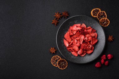 Tatlı tatlılar için bir malzeme olarak kurumuş sublimleşmiş çilek dilimleri. Tasarımınız için yemek arkaplanı olarak kurutulmuş çilek