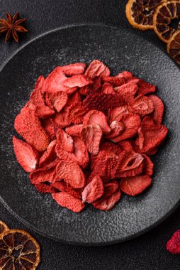 Tatlı tatlılar için bir malzeme olarak kurumuş sublimleşmiş çilek dilimleri. Tasarımınız için yemek arkaplanı olarak kurutulmuş çilek