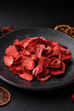 Tatlı tatlılar için bir malzeme olarak kurumuş sublimleşmiş çilek dilimleri. Tasarımınız için yemek arkaplanı olarak kurutulmuş çilek