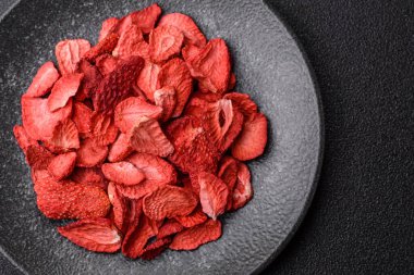 Tatlı tatlılar için bir malzeme olarak kurumuş sublimleşmiş çilek dilimleri. Tasarımınız için yemek arkaplanı olarak kurutulmuş çilek