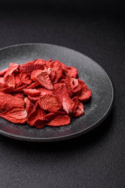 Tatlı tatlılar için bir malzeme olarak kurumuş sublimleşmiş çilek dilimleri. Tasarımınız için yemek arkaplanı olarak kurutulmuş çilek