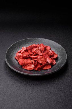 Tatlı tatlılar için bir malzeme olarak kurumuş sublimleşmiş çilek dilimleri. Tasarımınız için yemek arkaplanı olarak kurutulmuş çilek