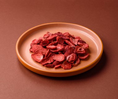 Tatlı tatlılar için bir malzeme olarak kurumuş sublimleşmiş çilek dilimleri. Tasarımınız için yemek arkaplanı olarak kurutulmuş çilek