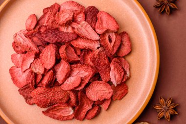 Tatlı tatlılar için bir malzeme olarak kurumuş sublimleşmiş çilek dilimleri. Tasarımınız için yemek arkaplanı olarak kurutulmuş çilek