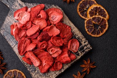 Tatlı tatlılar için bir malzeme olarak kurumuş sublimleşmiş çilek dilimleri. Tasarımınız için yemek arkaplanı olarak kurutulmuş çilek