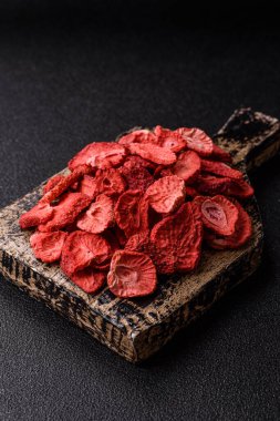 Tatlı tatlılar için bir malzeme olarak kurumuş sublimleşmiş çilek dilimleri. Tasarımınız için yemek arkaplanı olarak kurutulmuş çilek