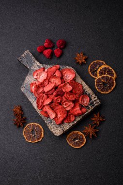 Tatlı tatlılar için bir malzeme olarak kurumuş sublimleşmiş çilek dilimleri. Tasarımınız için yemek arkaplanı olarak kurutulmuş çilek