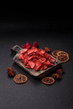 Tatlı tatlılar için bir malzeme olarak kurumuş sublimleşmiş çilek dilimleri. Tasarımınız için yemek arkaplanı olarak kurutulmuş çilek