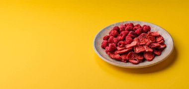 Tatlı tatlılar için bir malzeme olarak kurumuş sublimleşmiş çilek dilimleri. Kurutulmuş çilek ve ahududu, tasarımınız için gıda arka planıdır.