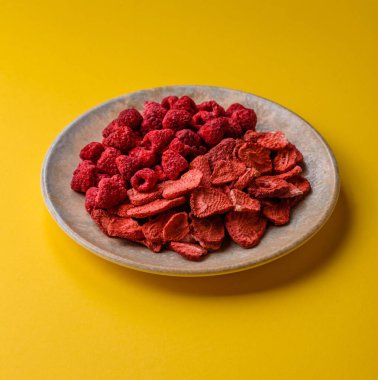 Tatlı tatlılar için bir malzeme olarak kurumuş sublimleşmiş çilek dilimleri. Kurutulmuş çilek ve ahududu, tasarımınız için gıda arka planıdır.