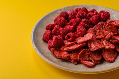 Tatlı tatlılar için bir malzeme olarak kurumuş sublimleşmiş çilek dilimleri. Kurutulmuş çilek ve ahududu, tasarımınız için gıda arka planıdır.