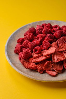 Tatlı tatlılar için bir malzeme olarak kurumuş sublimleşmiş çilek dilimleri. Kurutulmuş çilek ve ahududu, tasarımınız için gıda arka planıdır.