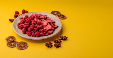 Tatlı tatlılar için bir malzeme olarak kurumuş sublimleşmiş çilek dilimleri. Kurutulmuş çilek ve ahududu, tasarımınız için gıda arka planıdır.