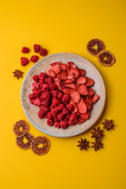 Tatlı tatlılar için bir malzeme olarak kurumuş sublimleşmiş çilek dilimleri. Kurutulmuş çilek ve ahududu, tasarımınız için gıda arka planıdır.