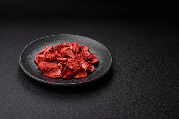 Tatlı tatlılar için bir malzeme olarak kurumuş sublimleşmiş çilek dilimleri. Tasarımınız için yemek arkaplanı olarak kurutulmuş çilek