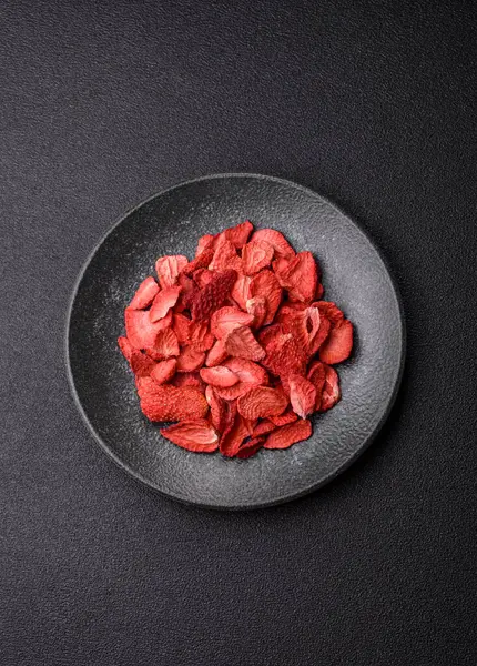 Tatlı tatlılar için bir malzeme olarak kurumuş sublimleşmiş çilek dilimleri. Tasarımınız için yemek arkaplanı olarak kurutulmuş çilek