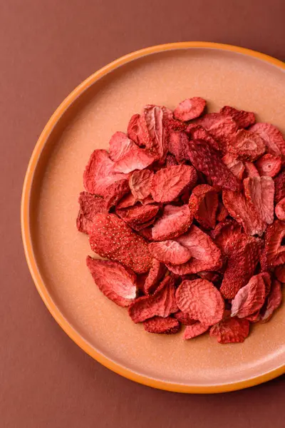 Tatlı tatlılar için bir malzeme olarak kurumuş sublimleşmiş çilek dilimleri. Tasarımınız için yemek arkaplanı olarak kurutulmuş çilek