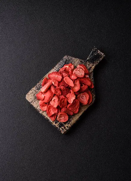 Tatlı tatlılar için bir malzeme olarak kurumuş sublimleşmiş çilek dilimleri. Tasarımınız için yemek arkaplanı olarak kurutulmuş çilek