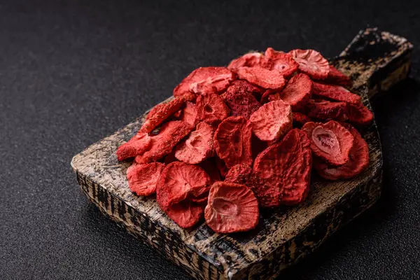 Tatlı tatlılar için bir malzeme olarak kurumuş sublimleşmiş çilek dilimleri. Tasarımınız için yemek arkaplanı olarak kurutulmuş çilek
