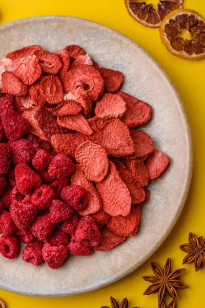 Tatlı tatlılar için bir malzeme olarak kurumuş sublimleşmiş çilek dilimleri. Kurutulmuş çilek ve ahududu, tasarımınız için gıda arka planıdır.