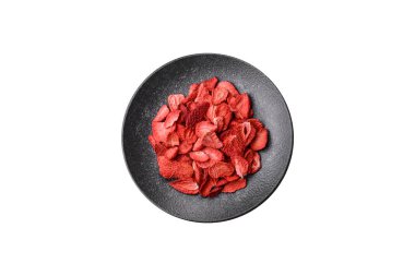 Tatlı tatlılar için bir malzeme olarak kurumuş sublimleşmiş çilek dilimleri. Tasarımınız için yemek arkaplanı olarak kurutulmuş çilek